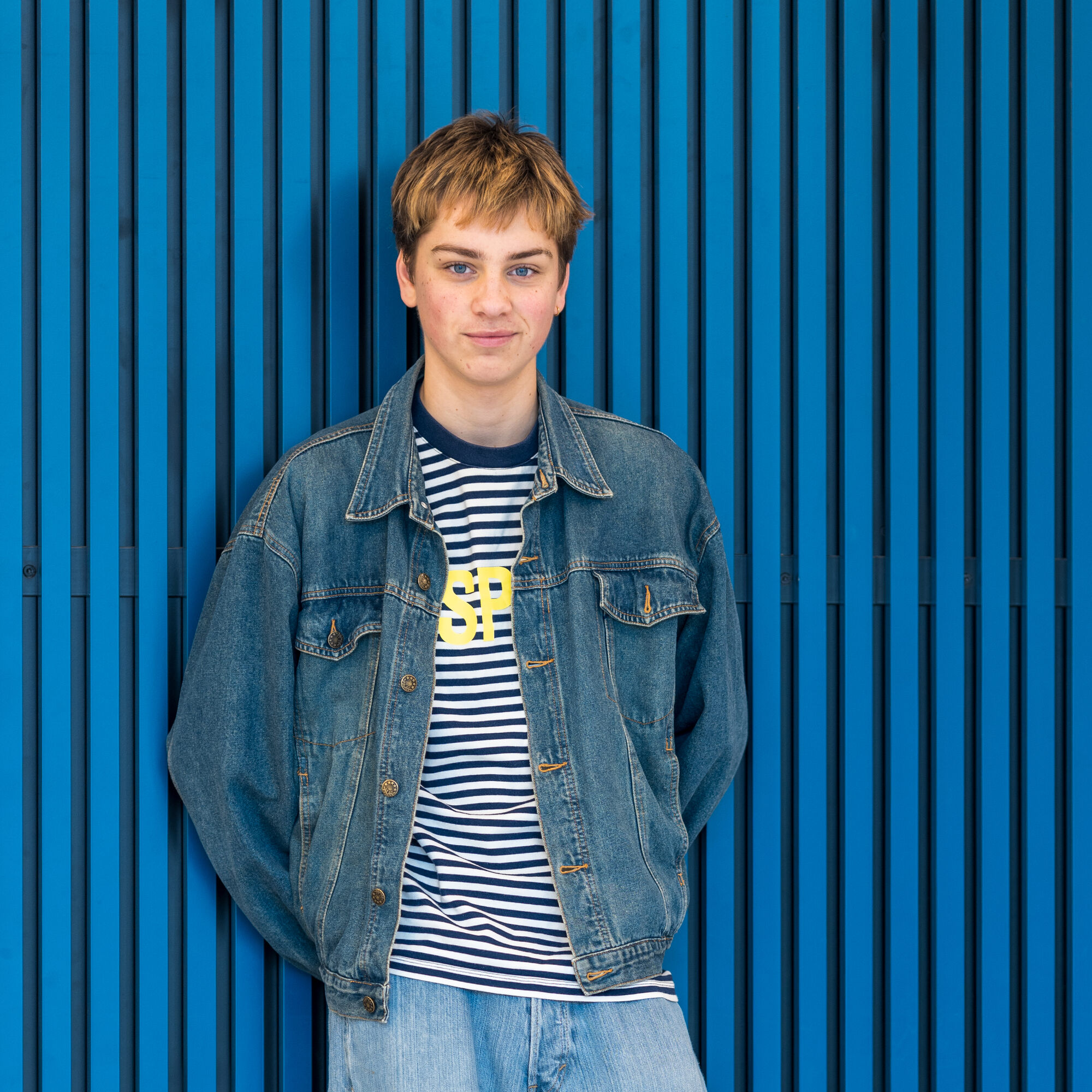 Lou Goossens poseert voor blauwe achtergrond