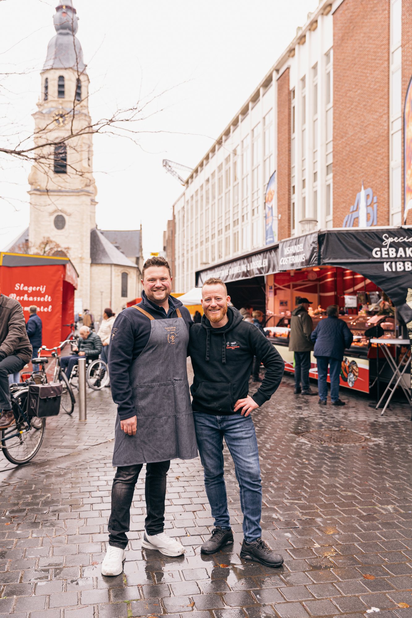 Twee jonge marktkramers poseren op de markt op het Kerkplein in Puurs