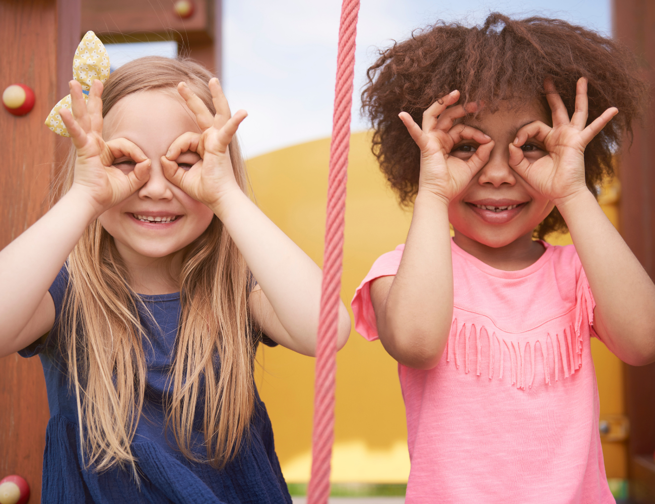 Twee kinderen die vingers rond ogen houden